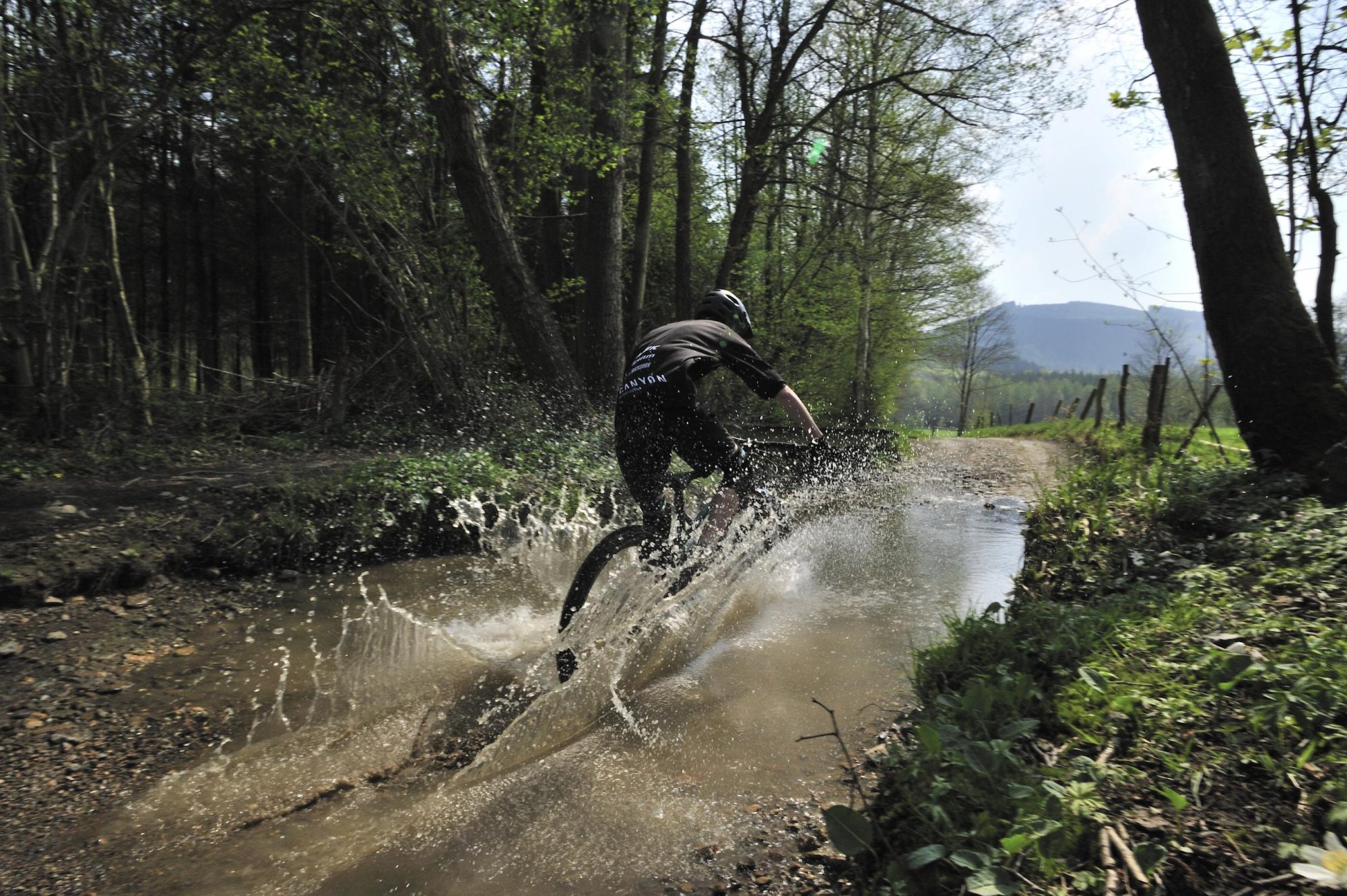 Un vététiste traverse une flaque d'eau
